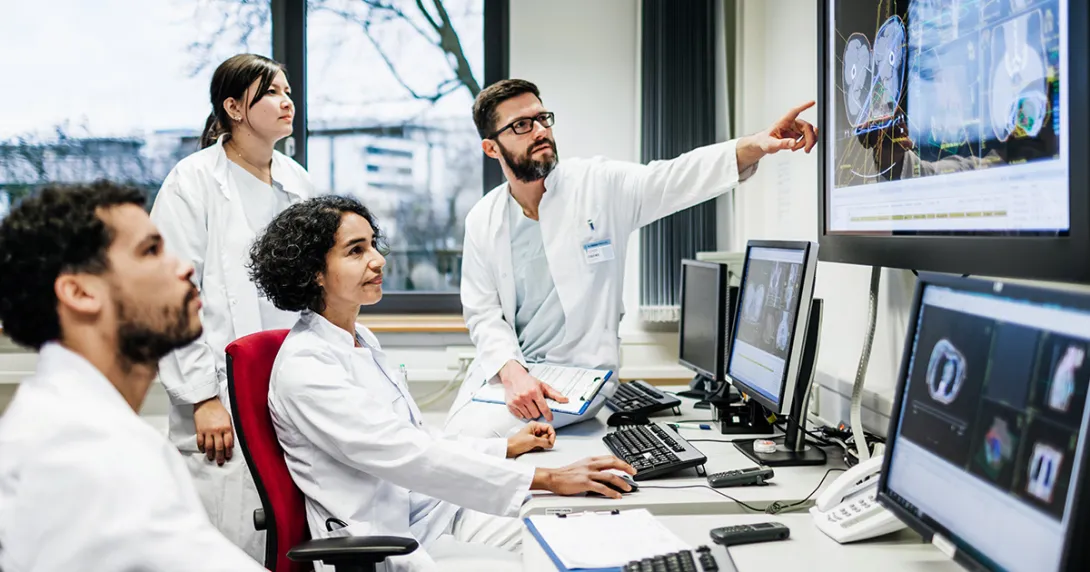 Healthcare workers looking at a medical image on a monitor