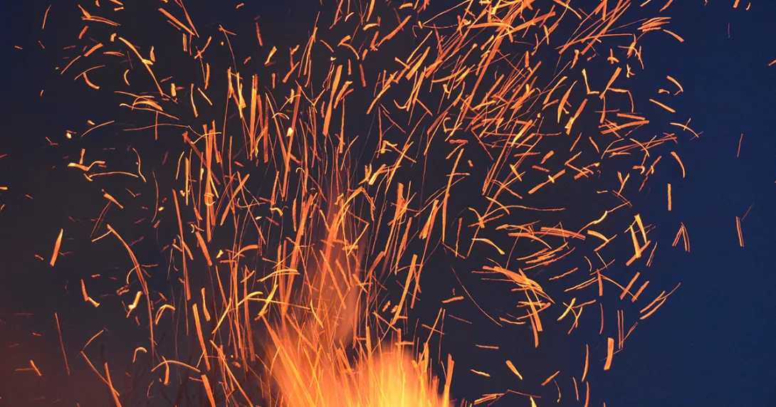 sparks from a fire under a dark sky