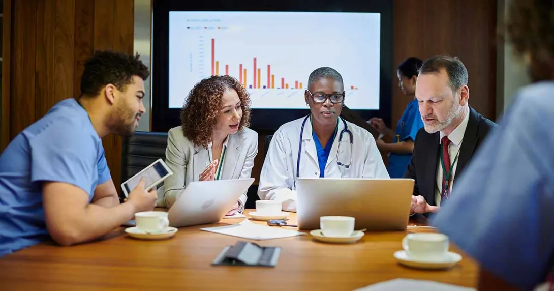 Medical professionals meeting with a graph in the background