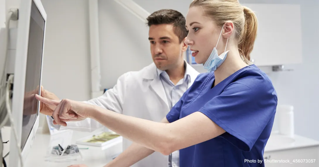 Healthcare worker pointing to a screen with another in the background