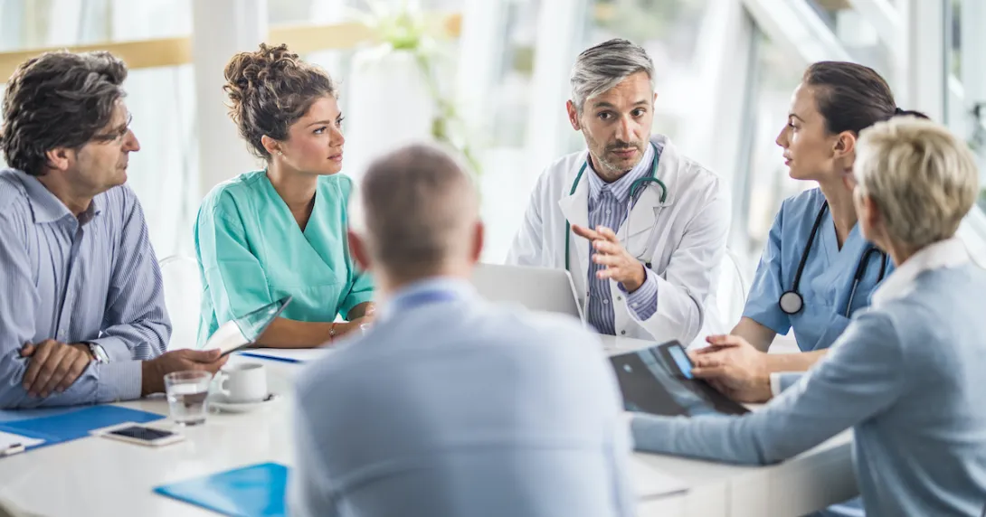 Doctors and payers sit around a table discussing claims data, prior authorizations and more.