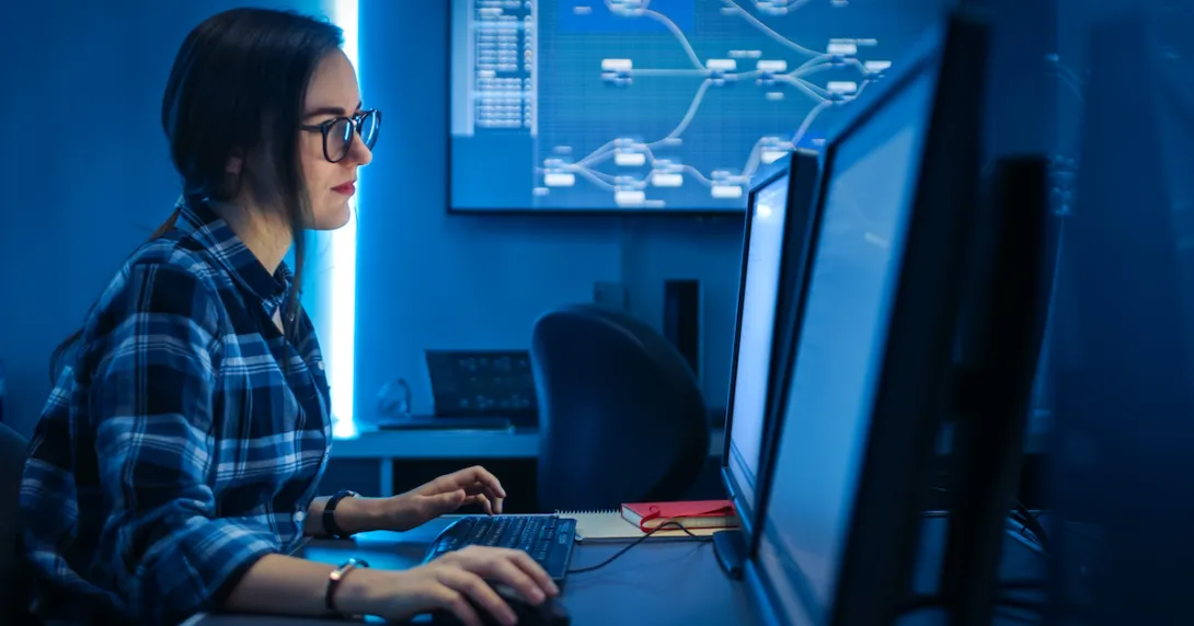 An IT person working on codes on a desktop computer