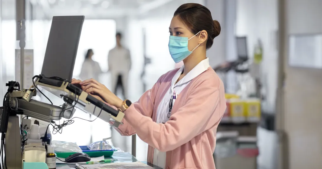 A nurse using a laptop to write a medical report