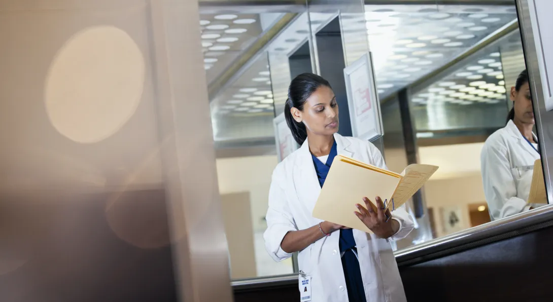 A doctor reviewing a patient's paper record