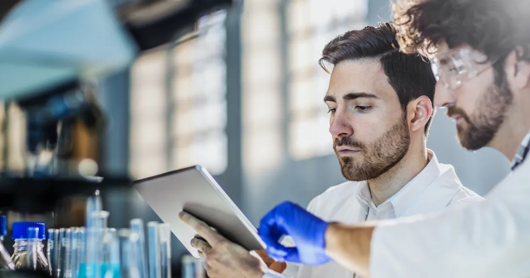 Scientists working on a lab experiment using a digital tablet