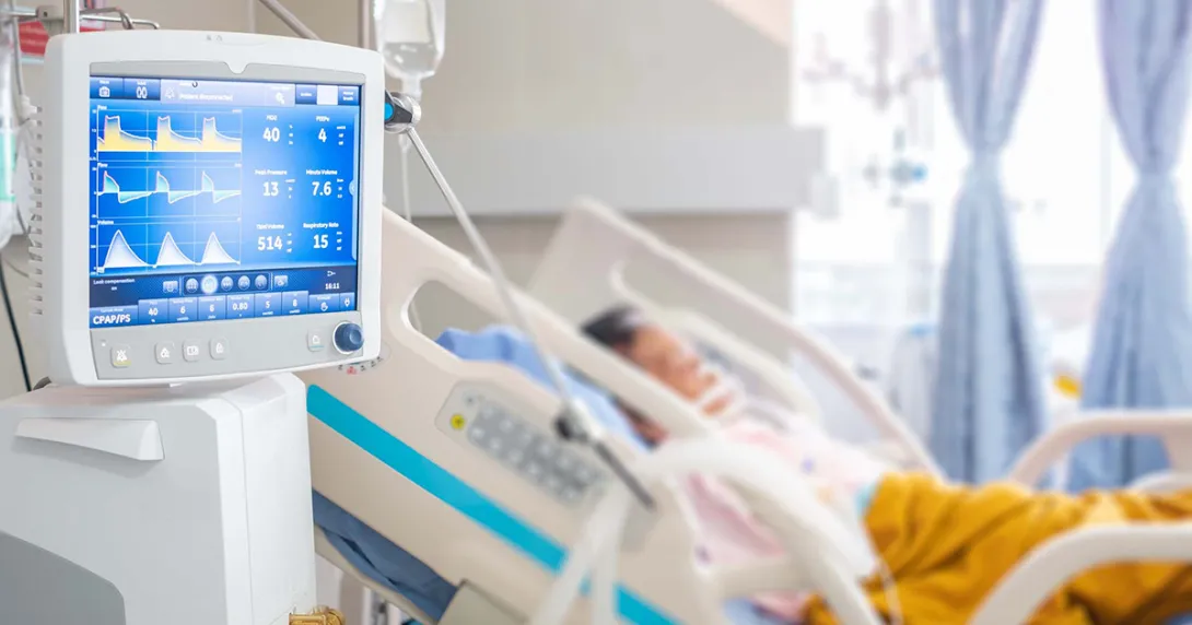 Patient in hospital bed with vital sign monitor