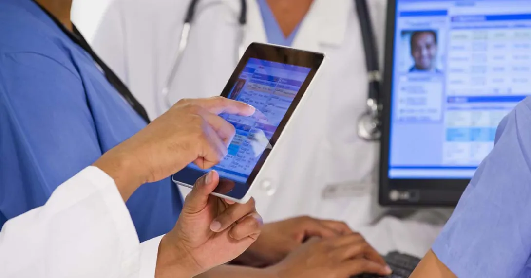 Healthcare workers looking at a medical record on a tablet