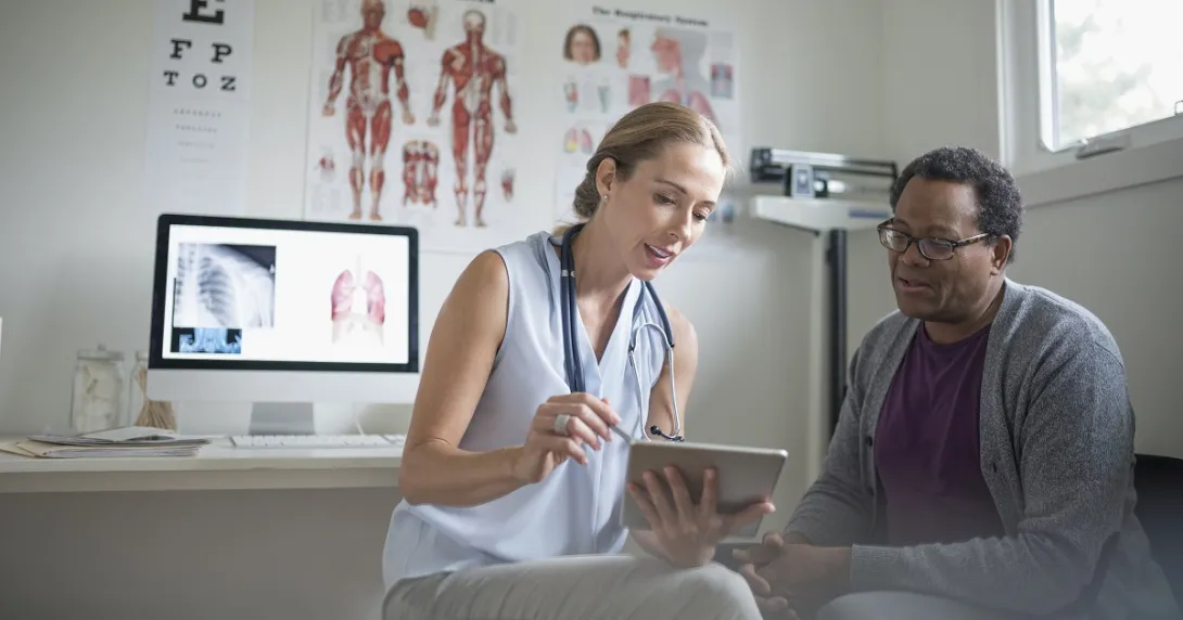 Doctor reviews data on a tablet with a patient