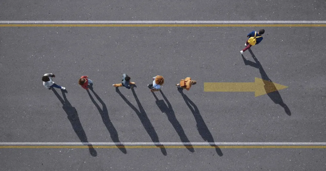 Top down view of people walking in a line on a road