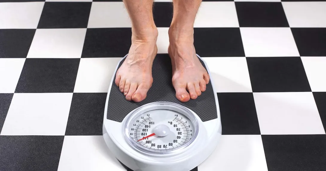 Feet on a scale on a black and white checkerboard floor