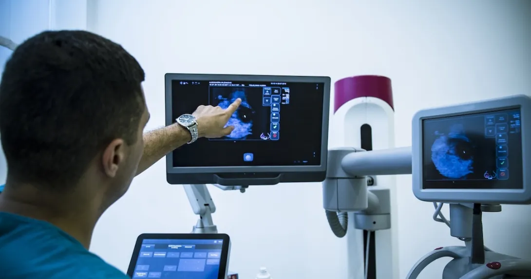 Healthcare worker pointing at x-ray image on monitor