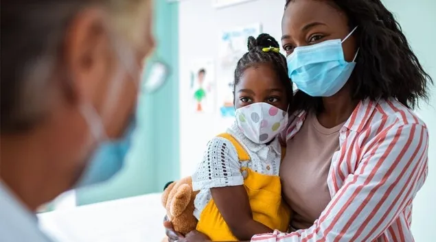 Parent and child in mask talking to doctor in mask