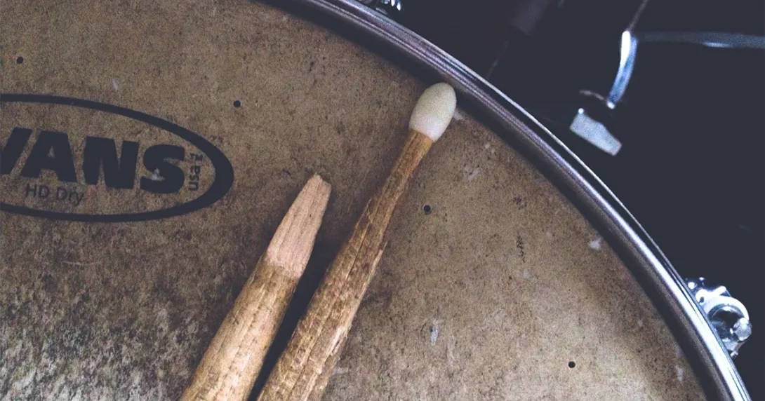 Close-up of broken drum stick that lays across an old snare drum
