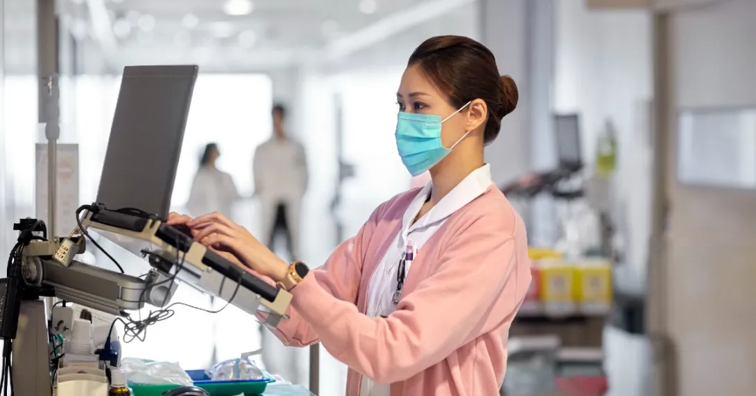 A clinician works in an EHR on a hospital floor.