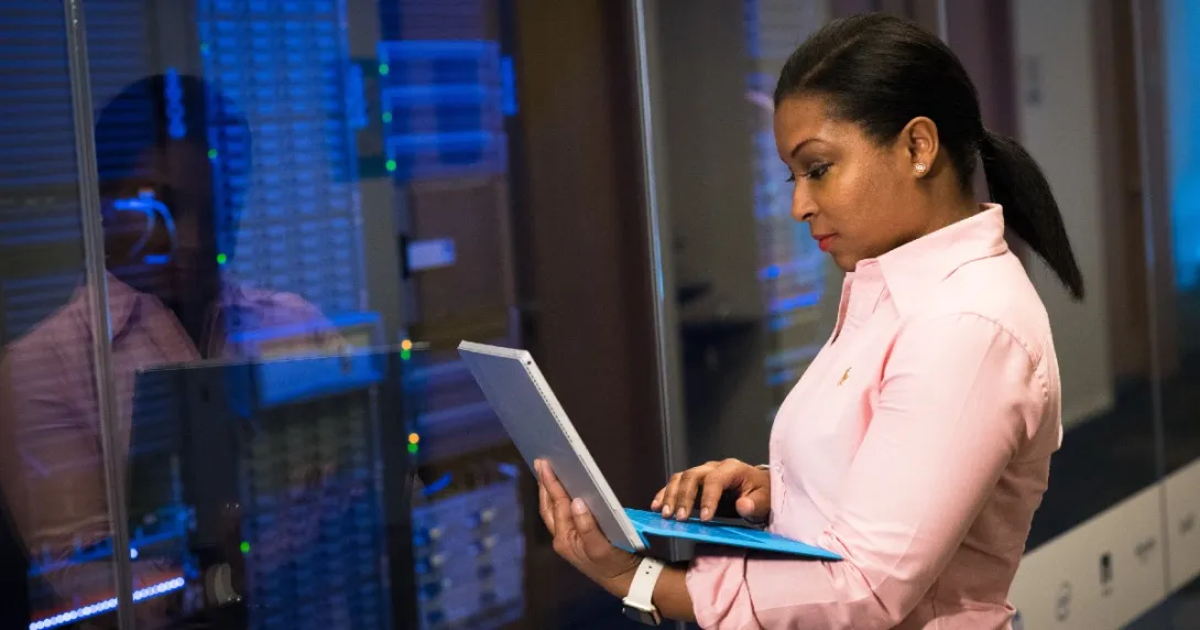 IT checks info on laptop in front of IT room