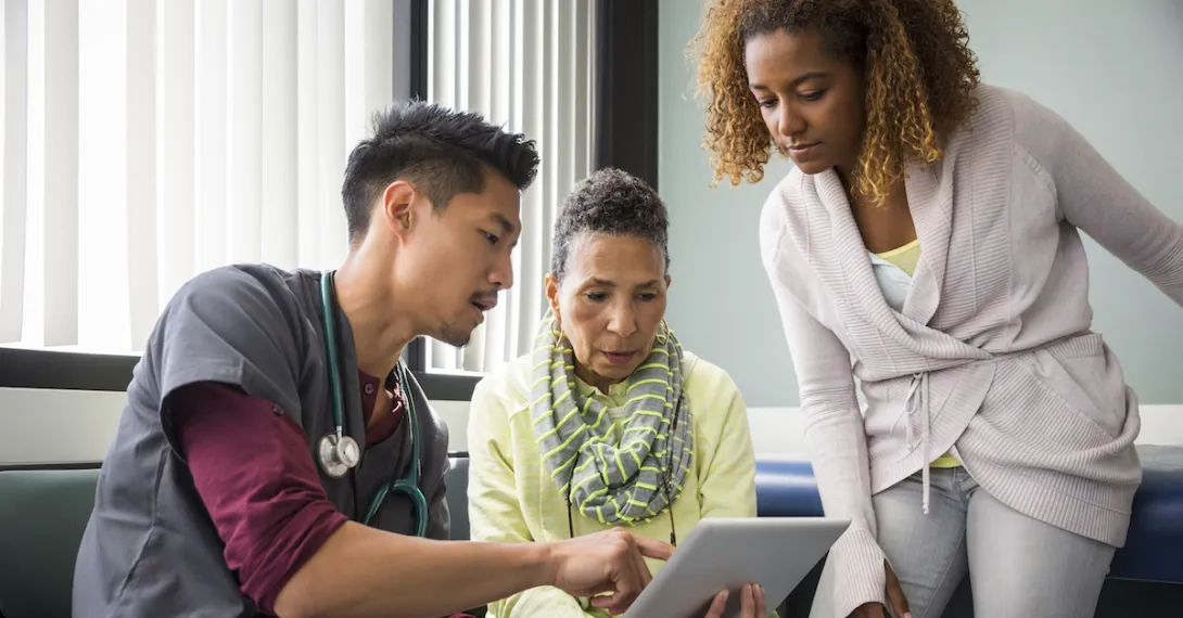 Healthcare worker showing tablet to patients