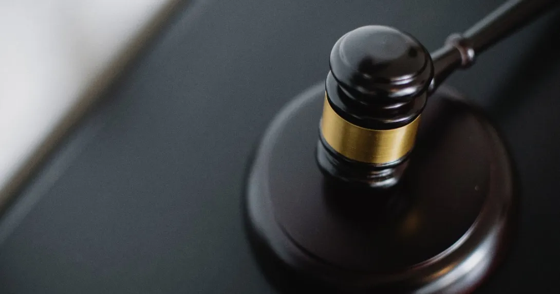 A black gavel lays on a desk