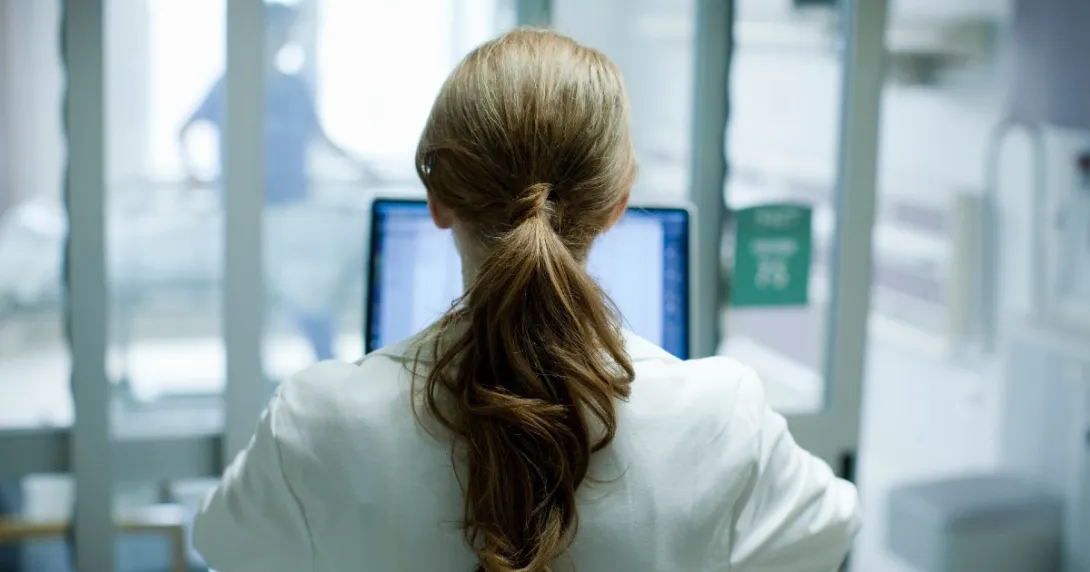 Doctor with long hair at laptop