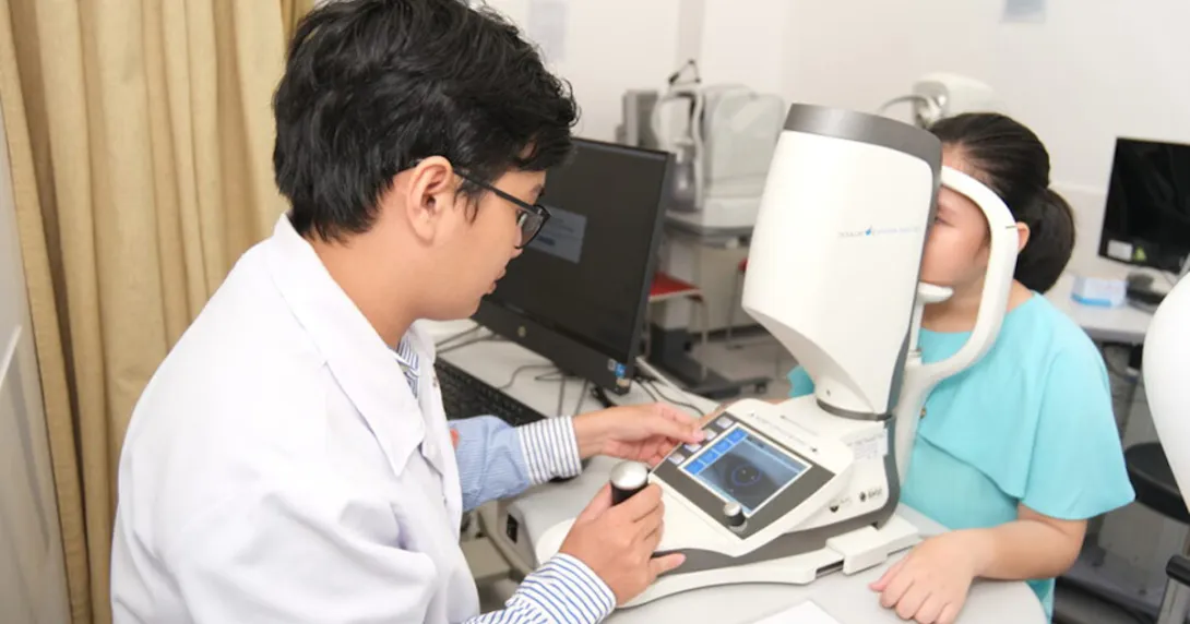A FV Hospital doctor using the Myopia Master for screening a young patient