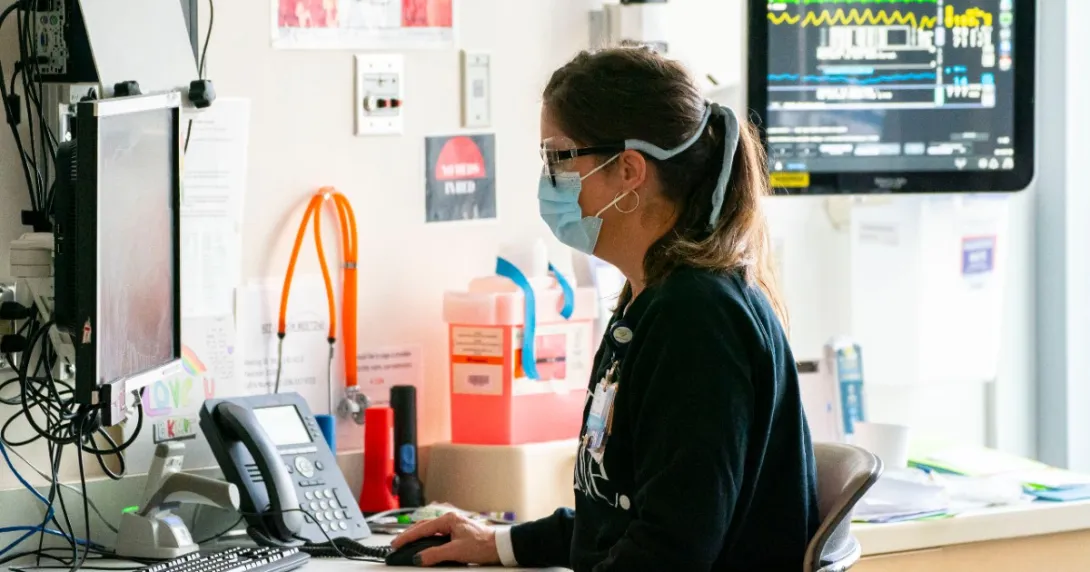 public health nurse examines data on a computer