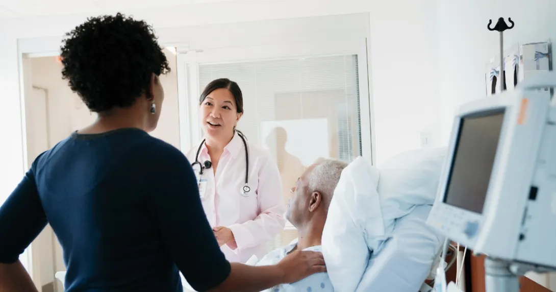 Doctor with hospital patient and another person standing