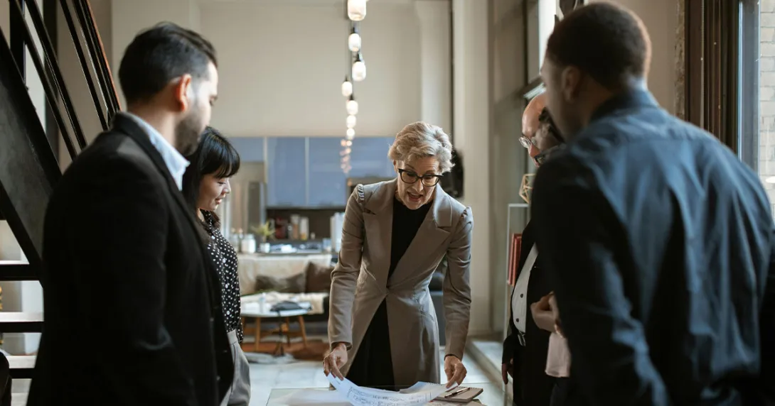 Developers around a table with documents discussing product life cycles