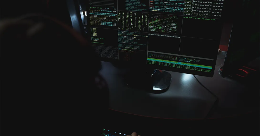 monitor on dark desktop shows multiple screens of data