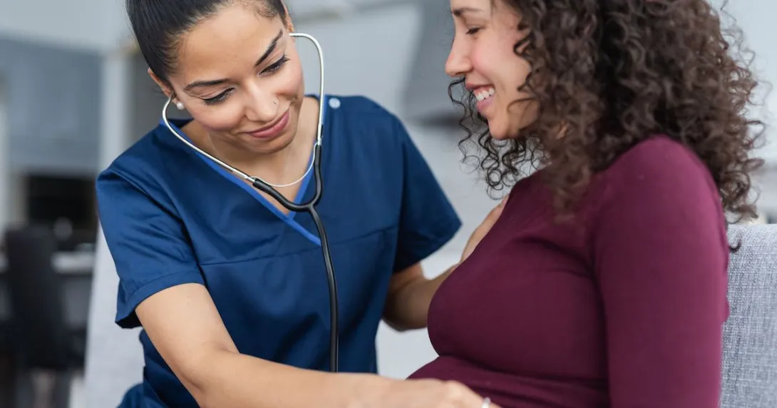 Doctor examining pregnant person with stethoscope