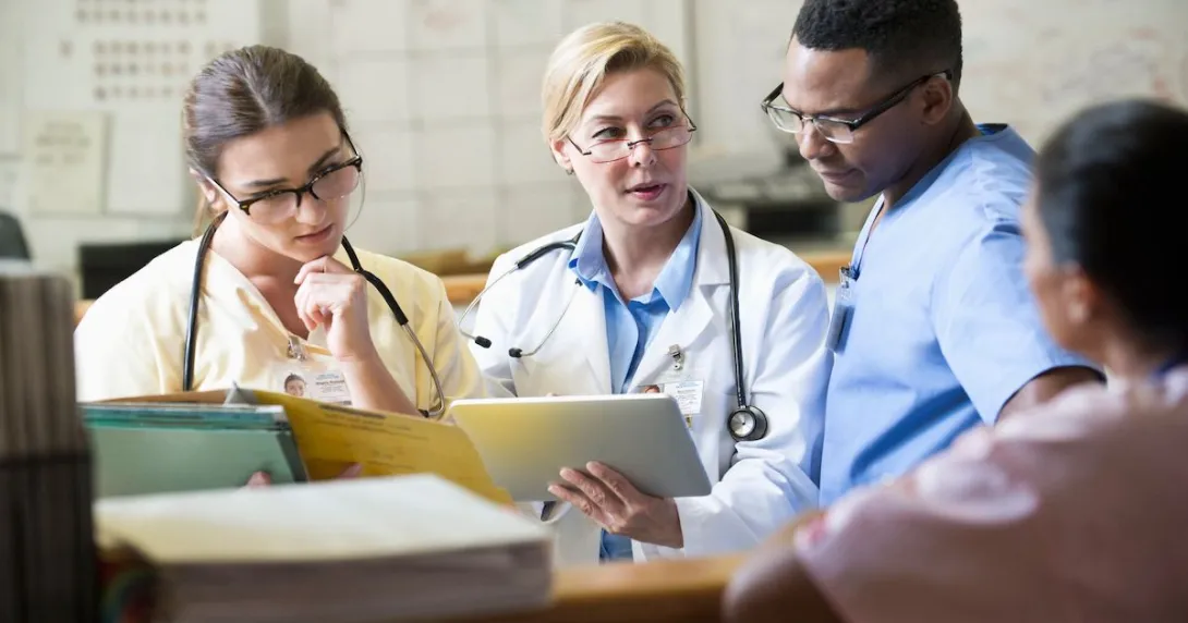 Clinicians discussing around a nurses' station.