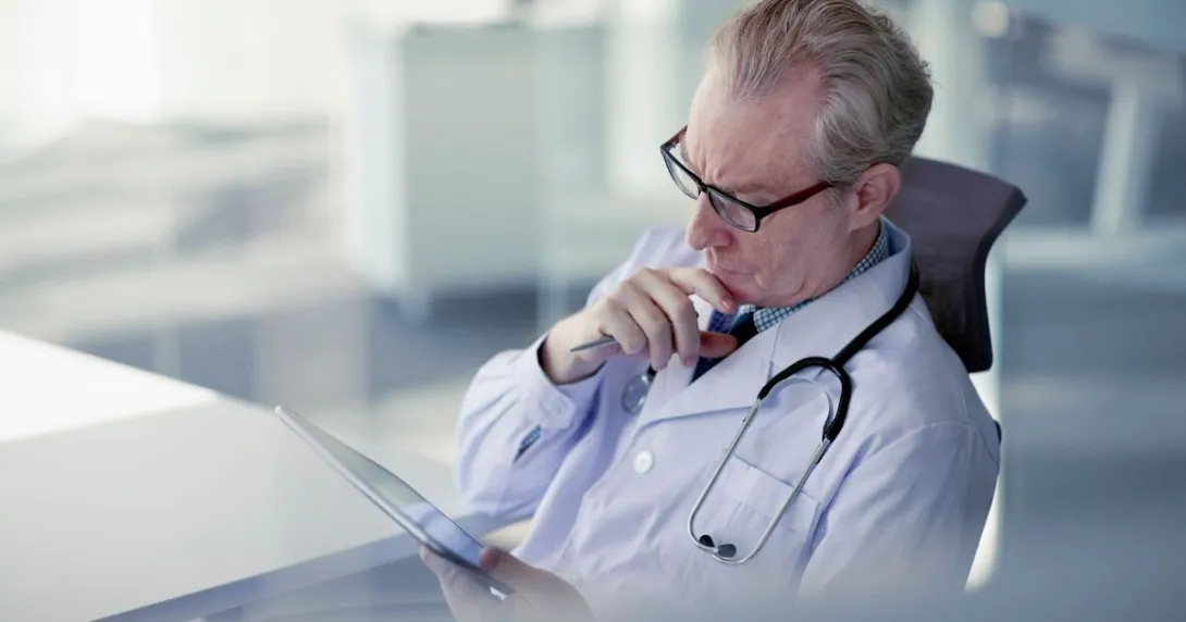 Doctor in a chair looking at a tablet