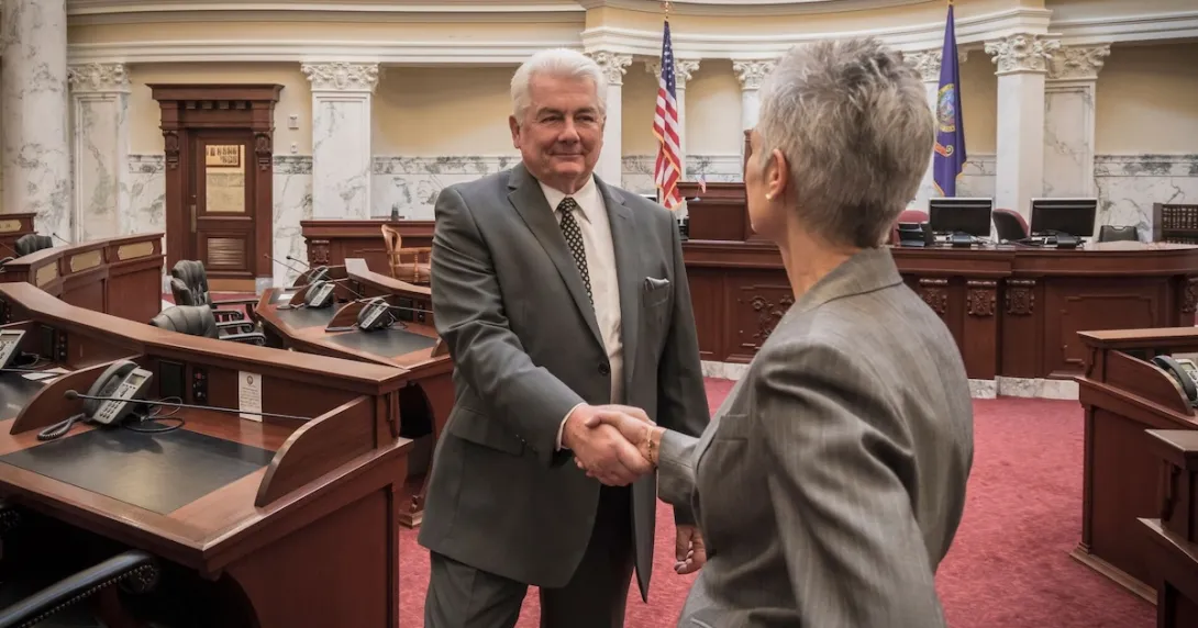 Politicians shaking hands in legislative chamber