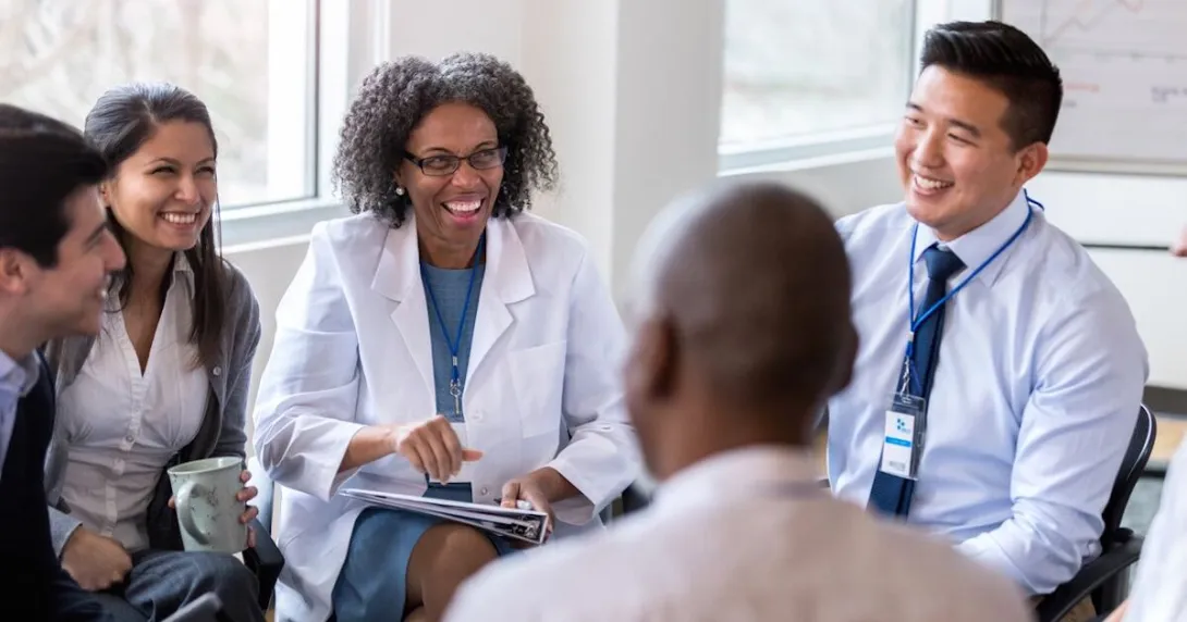 Hospital workers sit around in a meeting