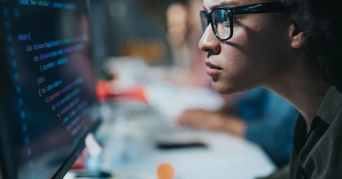 A computer programmer writing codes on a desktop computer
