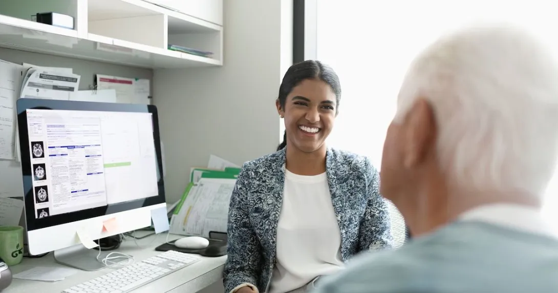 A smiling doctor facing a patient in a consultation