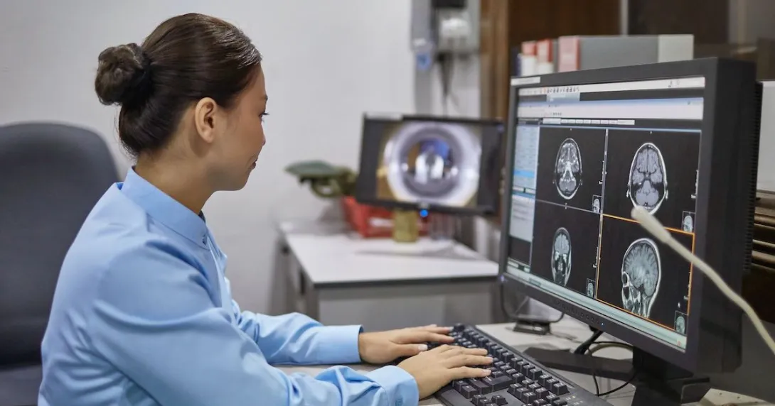 Woman reviews medical imaging on a desktop computer