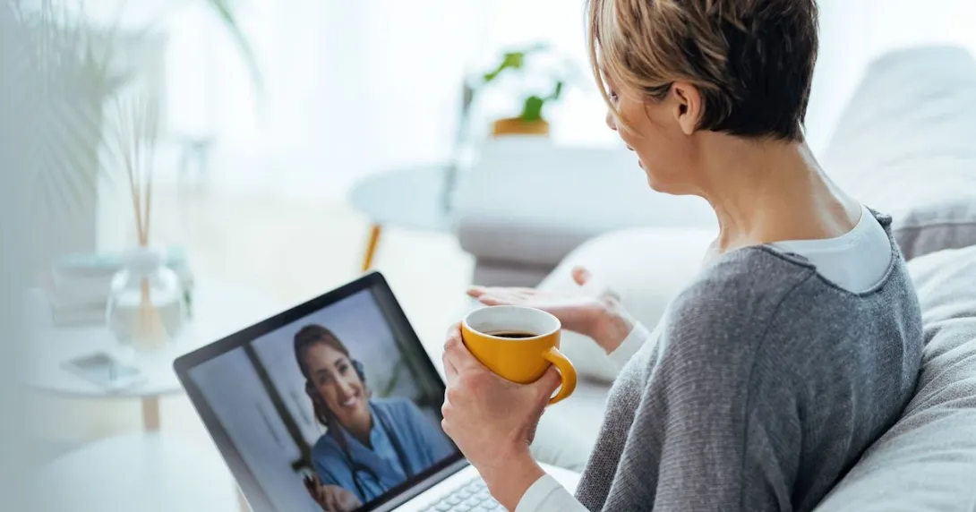 Alt text: A person consulting with a doctor via video call on a laptop