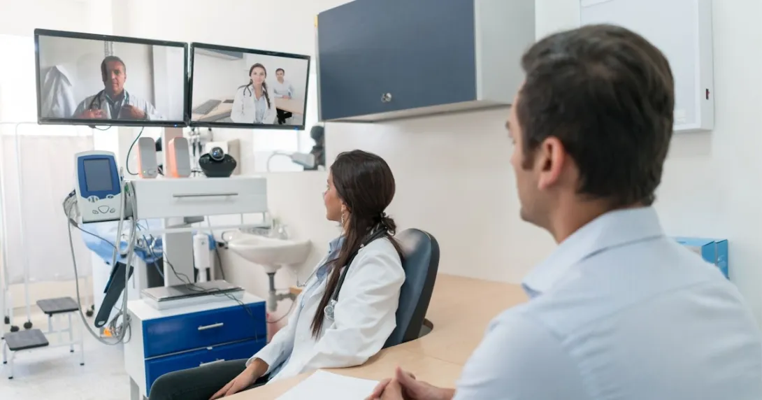 A doctor and their patient in a video conference with other specialists