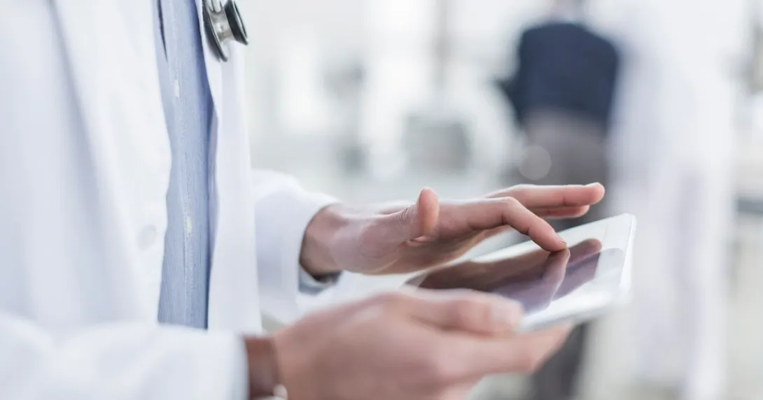 A doctor reviewing a patient's file on a digital tablet