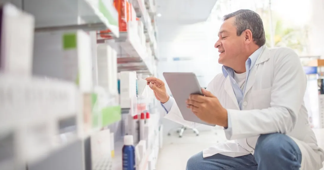 A pharmacist holding a digital tablet doing an inventory